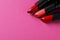Beautiful lipsticks on pink background, above view. Space for text