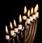 Beautiful lit hanukkah menorah on black.