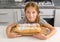 Beautiful litte girl with baked apple strudel on table