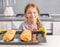 Beautiful litte girl with baked apple strudel on table