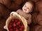 A beautiful little 6 months girl with a basket of strawberries. A healthy smiling child. Happy Motherhood