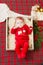 Beautiful little baby celebrates Christmas. New Year`s holidays. Baby in a Christmas costume