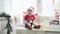 Beautiful little baby celebrates Christmas. New Year`s holidays. Child in a Xmas costume with gift. Santa Kid