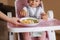 Beautiful little baby girl first time eating exotic fruits in high chair. Cute baby girl taste delitious fruist, mango