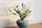 Beautiful little blue flowers in vase in warm sunlight on rustic wooden background. Delicate myosotis petals, forget me not spring