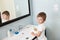 Beautiful little boy with toothbrush in hand in bright bathroom