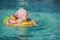 Beautiful Little cheerful girl swimming in the pool