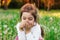 Beautiful little child smiling with dandelion flower in sunny summer park. Happy cute kid having fun outdoors at sunset.