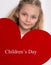 Beautiful little girl with amazing blue eyes and long blond hair holds in his hands Valentine red heart