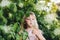 Beautiful little girl blowing dandelion and playing in park in summer, childhood and activity