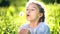 Beautiful little girl blowing dandelion at summer day.