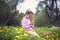 Beautiful little girl with chicken on hands. Little kid with pet sitting on grass. Childhood in the countryside. Small farmer. Gir