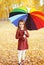 Beautiful little girl child with colorful umbrella in autumn