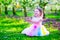 Beautiful little girl in fairy costume feeding a bird