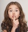 Beautiful little girl with finger on lips f