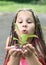 Beautiful little girl. A girl with African pigtails eats plums.