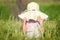 A beautiful little girl with a hat in a grain fiel