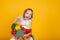 Beautiful little girl holding a basket of ripe vegetables