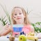 Beautiful little girl holding a fork with chocolate fondue.