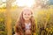 Beautiful little girl with long hair and smile in the summertime in the sunset park.