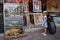 A beautiful little girl is looking at painting at street store