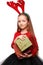 Beautiful little girl in a New Year`s image with boxes of gifts in hands and deer horns on her head.