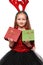 Beautiful little girl in a New Year`s image with boxes of gifts in hands and deer horns on her head.