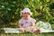 Beautiful little girl in panama sitting on meadow