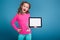 Beautiful little girl in pink shirt with monkey and blue trousers hold empty tablet