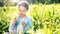 Beautiful little girl playing with flowers at summer day.