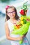 Beautiful little girl posing with a large bouquet of flowers. Girl with braces and glasses