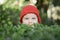 Beautiful little girl, with red cap in green plantations.