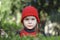 Beautiful little girl, with red cap in green plantations.