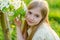 A beautiful little girl runs through a flowering garden in the s