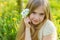 A beautiful little girl runs through a flowering garden in the s