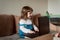 Beautiful little girl sitting on couch in living room and using laptop computer.Online training, games and watching cartoons. New
