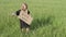 A beautiful little girl stands in a field with a poster and an hourglass