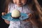 Beautiful little girl surprised from a tasty big chocolate coconut candy as a ball. Kid ready to eat cake