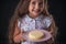 Beautiful little girl surprised from a tasty cheesecake. Kid ready to eat cake
