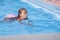 Beautiful little girl swims in the pool , cute little girl in pool in sunny day.