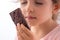 Beautiful little girl taste chocolate like a pro - breaking cacao bar, smelling, eating