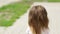 Beautiful little girl turns around and looks into the camera. Brunette, long, voluminous hair. Wreath of flowers.