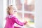 Beautiful little girl watching out of a window