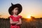 Beautiful little girl in witch costume on sunset background, free space.