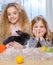 Beautiful little girls lying on carpet and playing with bunny.