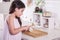 Beautiful little middle eastern 7 years old girl is working with knife and onion in the white kitchen. studio shot.