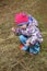 A beautiful little three year old girl collects dried flowers and considers them on your fingers