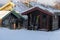 Beautiful little wooden mountain houses, huts surrounded by forest on a sunny winter day.