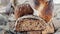 Beautiful loaves of wheat leaven bread with an assortment of grains and seeds on a plate on the edge of the canvas. Homemade cakes