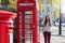 Beautiful London traveler woman stands next to a red telephone booth